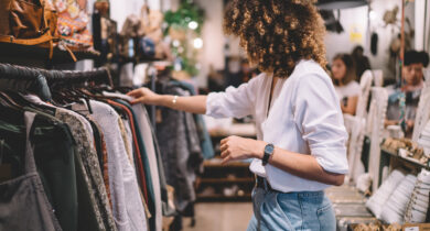 Mitarbeiterin ordnet die Kleider im Kleidergeschäft